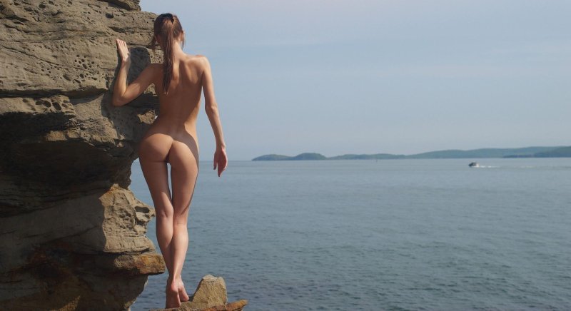 Голая загорает на скалах