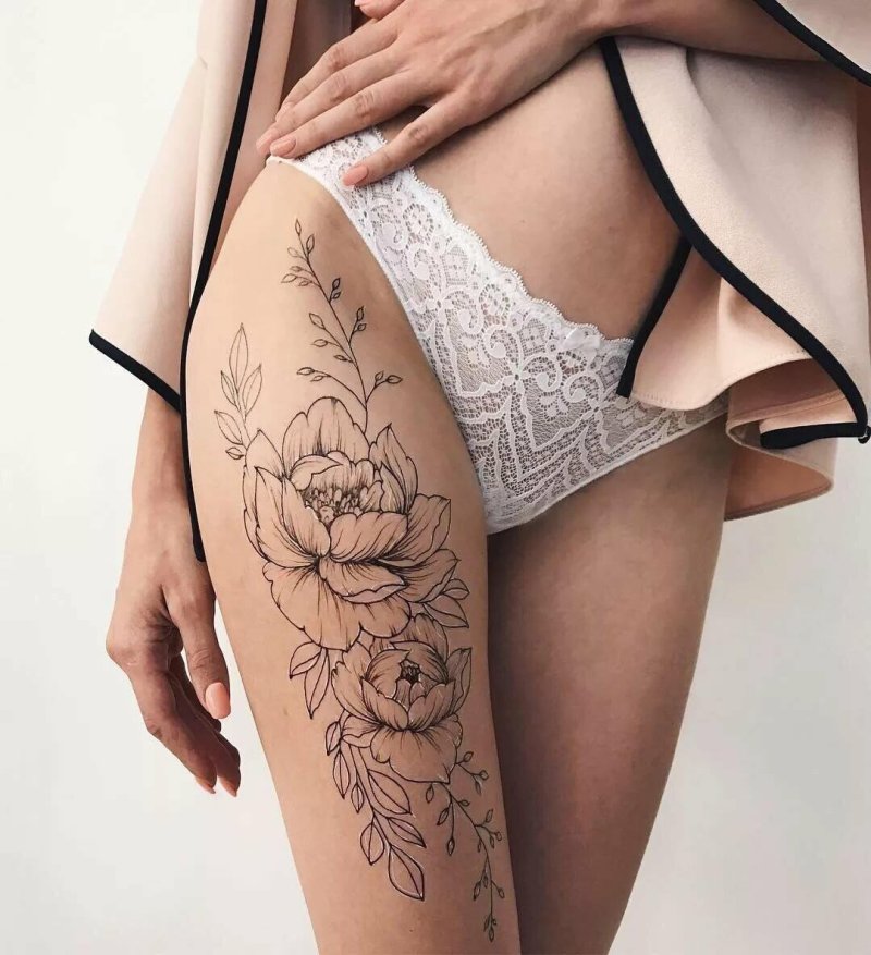 Женская татуировка на бедре