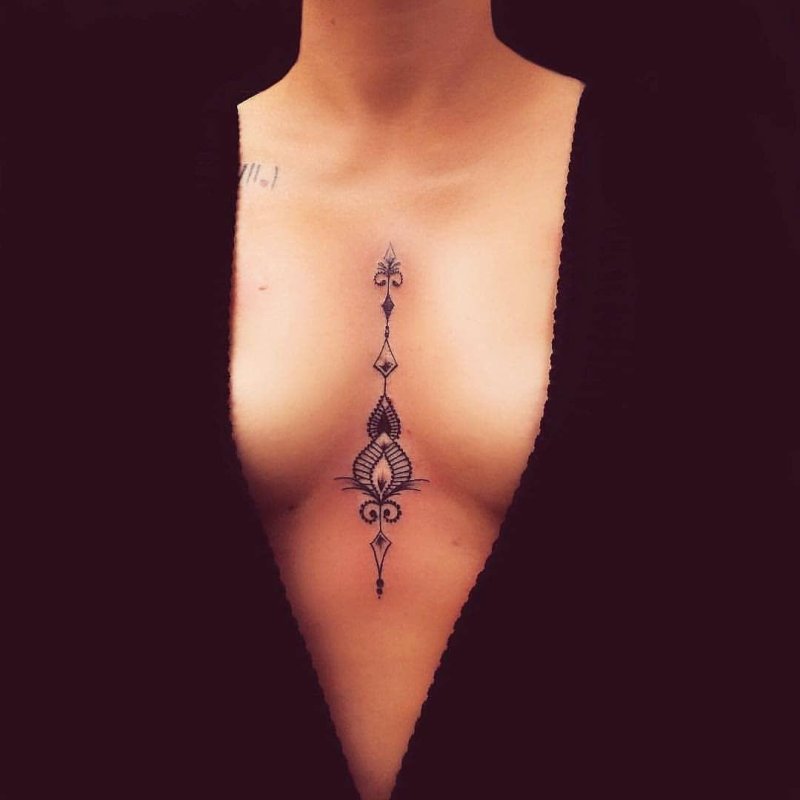 Тату между грудью женская