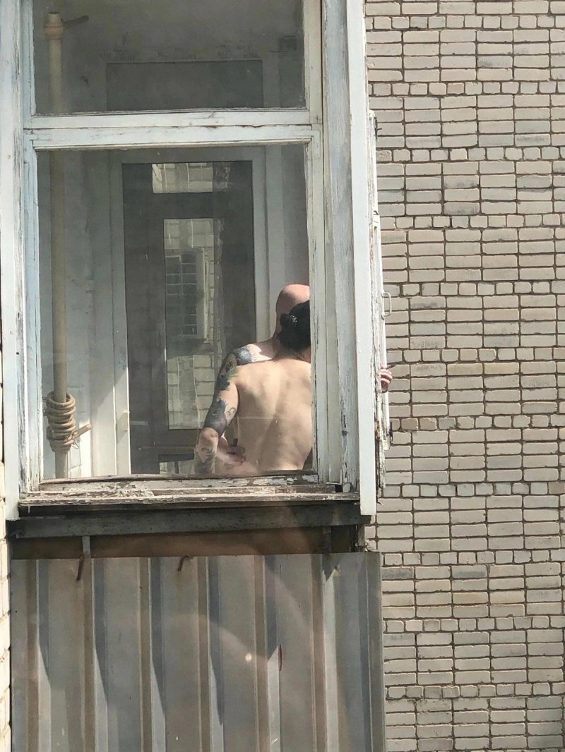 Курит на балконе