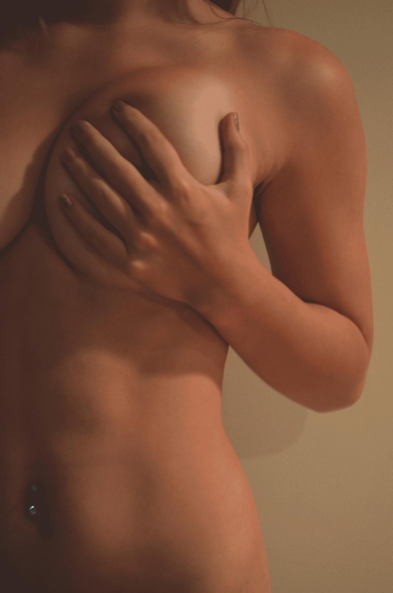 Девушка прикрывает грудь рукой