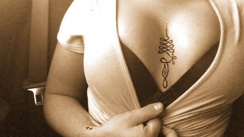 Тату между грудей у девушек