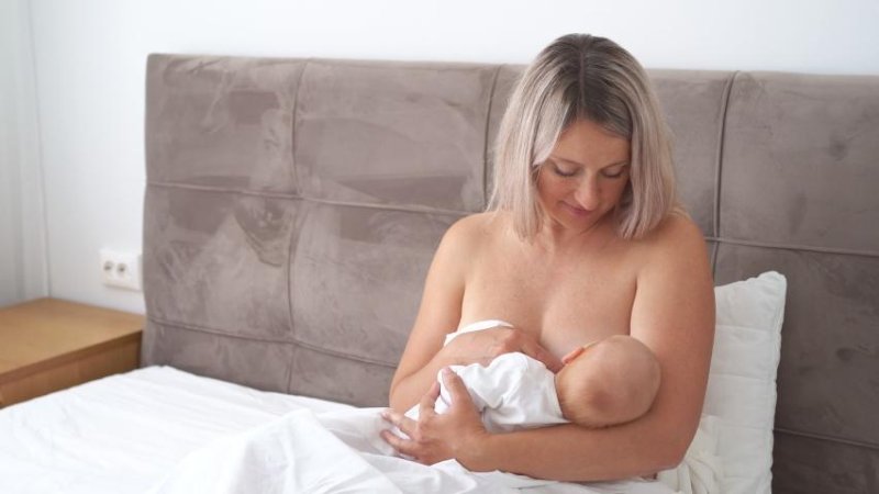 Кормит ребенка грудью