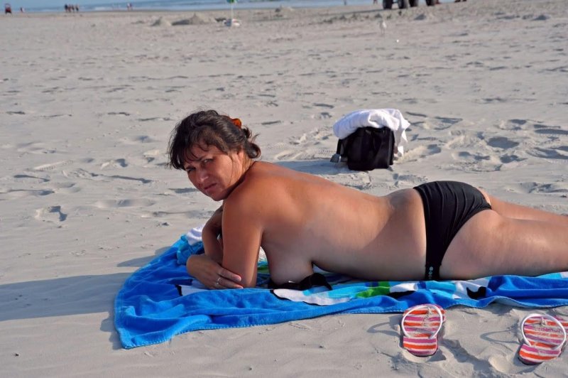 Зрелая переодевается на пляже