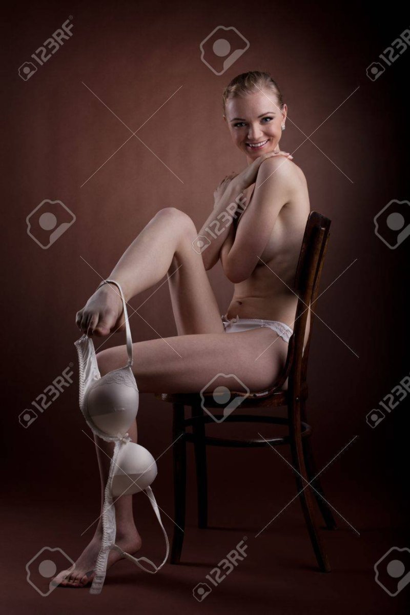 Голая женщина сидит на стуле
