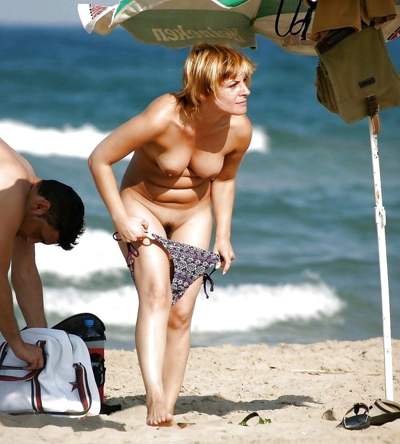 Женщина переодевает трусы на пляже